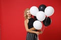 Cheerful young woman girl in black clothes posing isolated on bright red wall background in studio. New Year 2020 Royalty Free Stock Photo