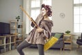 Happy young housewife playing on mop guitar and having fun while cleaning her house Royalty Free Stock Photo