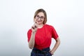 Cheerful young woman having nice glasses. pointing finger at camera, smiling