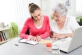 Cheerful young woman helping an elderly woman with pills medical prescription Royalty Free Stock Photo