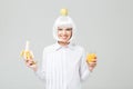 Cheerful young woman holding banana and glass of juice