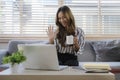 Cheerful young woman holding coffee cup and having video call on laptop computer Royalty Free Stock Photo