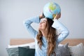 Cheerful young woman holding globe at home Royalty Free Stock Photo