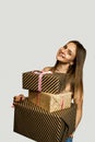 Cheerful young woman holding heap of presents, looking at camera, isolated on white background Royalty Free Stock Photo