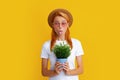 Cheerful young woman holding pot plant. Isolated yellow background, close up portrait. Plant care amd home gardening Royalty Free Stock Photo