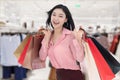 Cheerful young woman holding shopping bag at mall Royalty Free Stock Photo