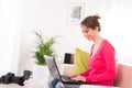 Cheerful young woman at home with laptop computer