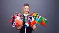 Cheerful young woman with a large set of flags of different countries of the world Royalty Free Stock Photo