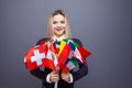 Cheerful young woman with a large set of flags of different countries of the world Royalty Free Stock Photo