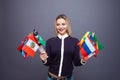 Cheerful young woman with a large set of flags of different countries of the world Royalty Free Stock Photo