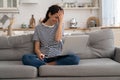 Cheerful young woman laugh while watch funny video on laptop at home sit with crossed legs on sofa Royalty Free Stock Photo