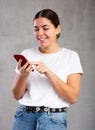 Cheerful young woman looking gladly at mobile Royalty Free Stock Photo