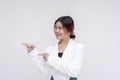 A cheerful young woman looking sideways while pointing both her fingers to the left side. Isolated on a white background Royalty Free Stock Photo