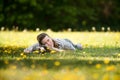 A cheerful, young woman lying on the grass with her pet. Royalty Free Stock Photo