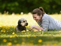A cheerful, young woman lying on the grass with her pet. Royalty Free Stock Photo