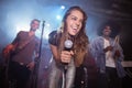 Cheerful young woman with musicians performing at nightclub Royalty Free Stock Photo