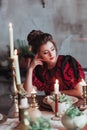 Cheerful young woman in old fashion dress reading book in restaurant decorated for Christmas. Waiting for date. Vertical Royalty Free Stock Photo