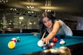 Cheerful young woman playing American billiards