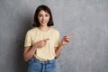 Cheerful young woman pointing fingers away at copy space Royalty Free Stock Photo