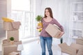 Cheerful young woman posing with plant and box Royalty Free Stock Photo