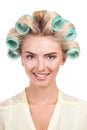 Cheerful young woman with rollers in her head