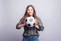 Cheerful young woman in shirt holding soccer ball over white wall Royalty Free Stock Photo