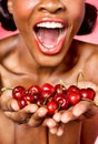 Cheerful young woman showing cherry in her hands Royalty Free Stock Photo