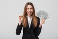 Cheerful young woman showing golden bitcoin and dollars in hands