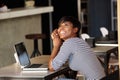 Cheerful young woman sitting at cafe with laptop Royalty Free Stock Photo