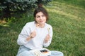 A young woman eating sushi in the park, picnic in nature. Royalty Free Stock Photo