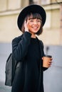 Cheerful young woman in the street drinking morning coffee in sunshine light Royalty Free Stock Photo