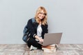 Cheerful young woman student using laptop computer. Royalty Free Stock Photo