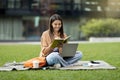 Cheerful young woman student working on project, using computer outdoors Royalty Free Stock Photo