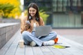 Cheerful young woman student working on project, using laptop, smartphone Royalty Free Stock Photo