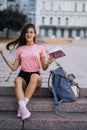 Cheerful young woman taking notes while sitting on steps otdoors Royalty Free Stock Photo