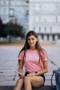 Cheerful young woman taking notes while sitting on steps otdoors Royalty Free Stock Photo