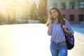 Cheerful young woman talking by phone outdoors with sunlight on her face and copy space Royalty Free Stock Photo