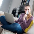 Cheerful young woman thinking about credit card to shop online