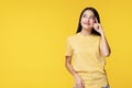 Cheerful woman use finger pointing to her head looking at product or empty copy space while standing over isolated on yellow Royalty Free Stock Photo