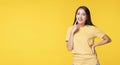 Cheerful young woman use finger pointing to her head looking at product or empty copy space while standing over isolated on yellow Royalty Free Stock Photo