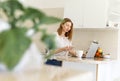 Cheerful young woman using laptop in office. Blogger, writer, journalist, student girl working on computer at home Royalty Free Stock Photo