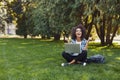 Cheerful young woman using laptop in park Royalty Free Stock Photo