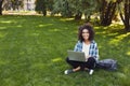 Cheerful young woman using laptop in park Royalty Free Stock Photo