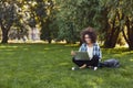 Cheerful young woman using laptop in park Royalty Free Stock Photo