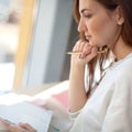 Cheerful young woman writing and keeping her personal a daily diary books. Royalty Free Stock Photo