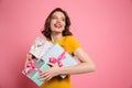 Cheerful young woman in yellow dress holding heap of presents Royalty Free Stock Photo