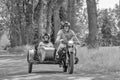 Cheerfull couple having a ride on a vintage motorcycle with side car.