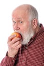 Cheerfull senior man eating the apple, isolated on white Royalty Free Stock Photo