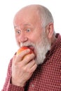 Cheerfull senior man eating the apple, isolated on white Royalty Free Stock Photo