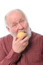 Cheerfull senior man eating the apple, isolated on white Royalty Free Stock Photo